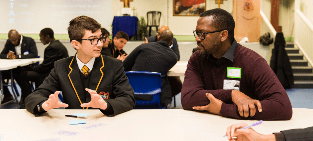 School pupil sits talking with an older mentor
